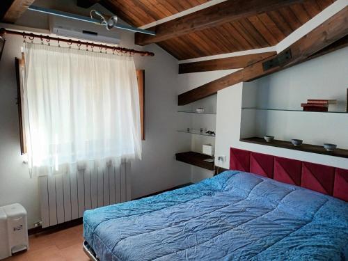 a bedroom with a blue bed and a window at La casa di Sergio in Bauladu