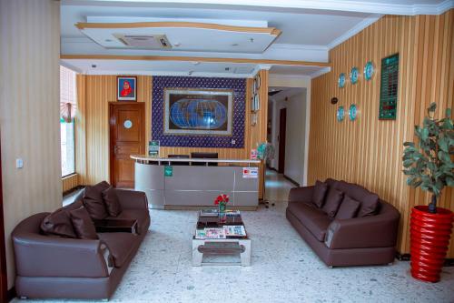 a living room with two couches and a table at Greenlight Hotel in Dar es Salaam