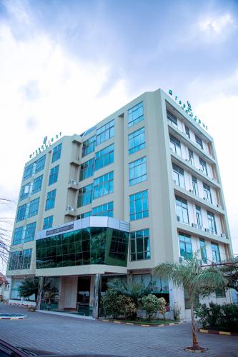 a large white building with windows on a street at Greenlight Hotel in Dar es Salaam