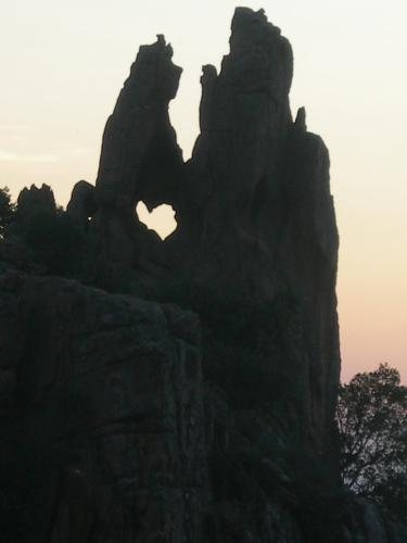 a silhouette of a rocky mountain with the sun setting at Petit coin de paradis, vue panoramique mer &montagne, piscine privée... in Calcatoggio