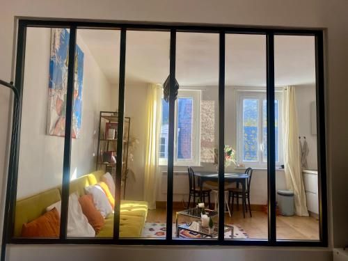 een woonkamer met een glazen schuifdeur en een tafel bij Les mouettes de Trouville in Trouville-sur-Mer