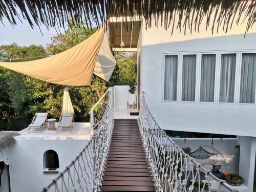a wooden walkway to a house with chairs on it at lory‘s home in Bangkok