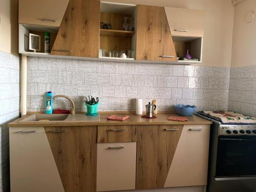 a kitchen with wooden cabinets and a sink and a stove at Flat 4you & WI-FI in Arad