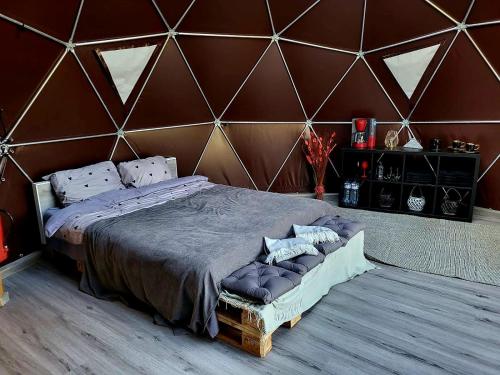 a bedroom with a large bed with a wooden wall at Ozoli - Pirts / Viesunams in Alande