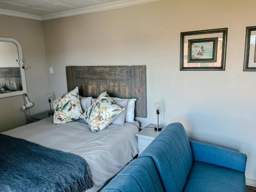 1 dormitorio con 1 cama y 1 sofá azul en Cozy Guest Suite, en Dana Bay