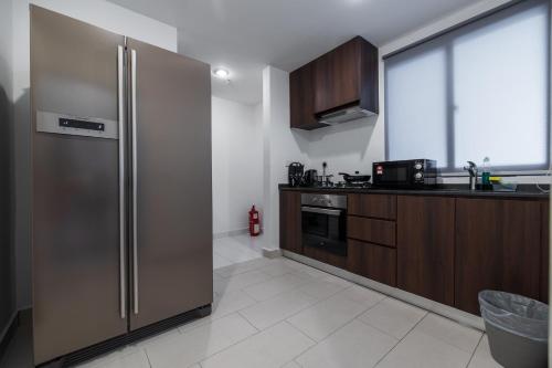 a kitchen with a stainless steel refrigerator and a window at Family Seaview Suite with 3 Rooms by The Only Bnb in Tanjong Tokong