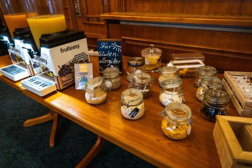 a wooden table with jars of food and other items on it at Berghotel Steiger - Erzgebirge in Schneeberg