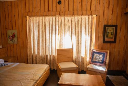 a bedroom with a bed and a window with curtains at SETHI's HOMESTAY in Srinagar