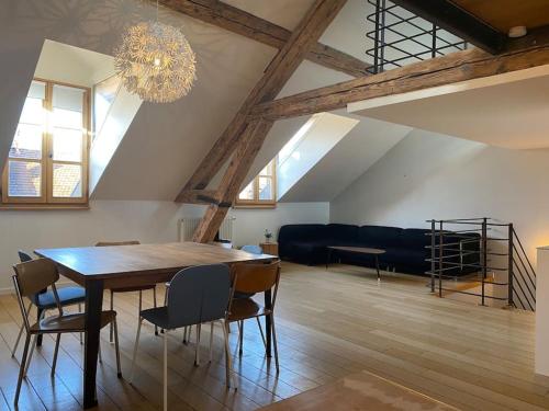 une salle à manger avec une table, des chaises et un lustre dans l'établissement Annecy City, au cœur de la vieille ville, à Annecy