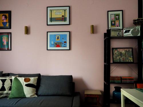 a living room with a couch and pictures on the wall at MimaDart Pop-up Gallery Apartment in Piraeus