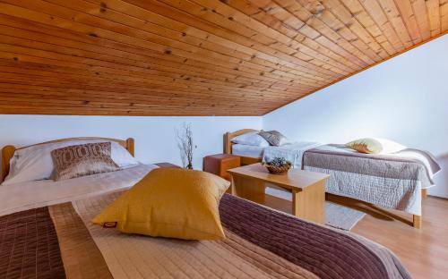 1 dormitorio con 2 camas y techo de madera en Sweet house with free parking, en Pula