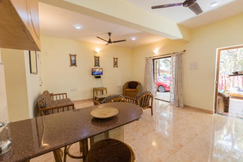 a dining room and living room with a table and chairs at Beach Village Holiday Homes Goa in Colva