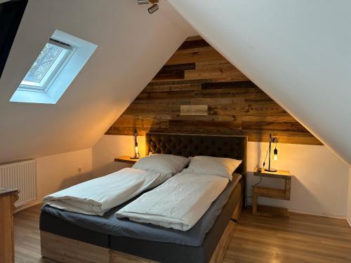 1 dormitorio con 1 cama con pared de madera en Chalet Ferienhaus Dresden en Dresden