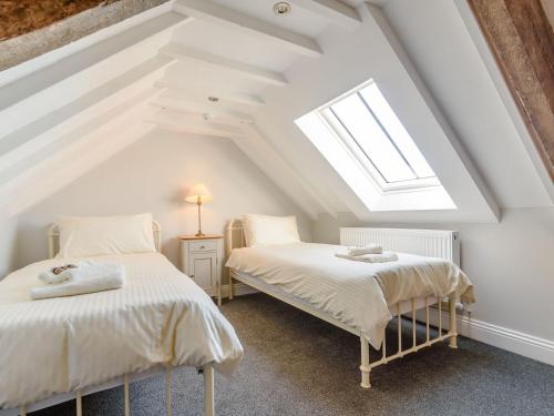 two beds in a attic room with a window at Lady De Seton - Uk31956 in Staithes