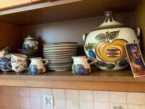 a shelf with plates and a vase on it at Apartament 65 m2 w centrum Łowicza in Łowicz