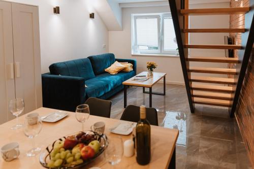 ein Wohnzimmer mit einem Sofa und einem Tisch mit einer Obstschale in der Unterkunft Kaszubski Raj in Chmielno