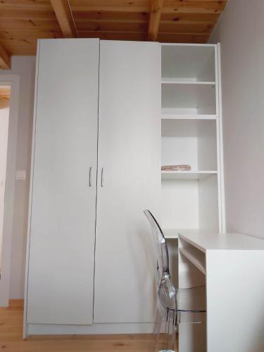 a white cabinet in a white room with a chair at SITIA CITY CENTER luxury apartment in Sitia