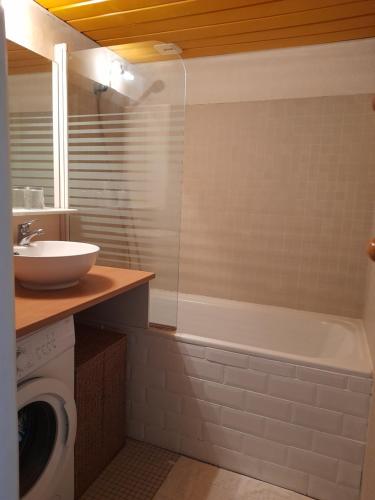 a bathroom with a sink and a tub and a toilet at studio Victoria Surf Biarritz in Biarritz