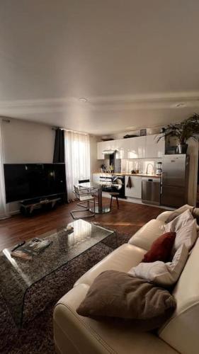 a living room with a couch and a kitchen at Appt de 50m2 Stade de France Canal Saint-Denis in Saint-Denis