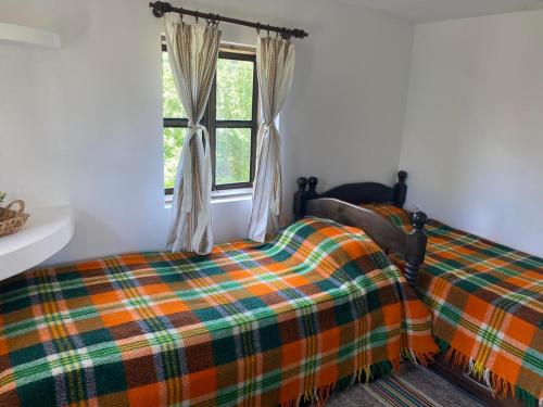 Schlafzimmer mit einem Bett und einem Fenster in der Unterkunft Къща за гости НОВЕ in Terziysko