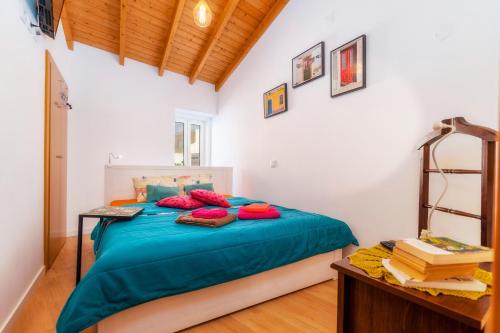 a bedroom with a bed with blue sheets and red pillows at Downtown Lady Terrace in Faro