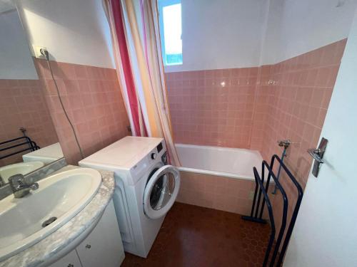 une salle de bain avec une machine à laver et un lavabo dans l'établissement 4VSE-COB279 Appartement proche plage avec parking privé, à Collioure