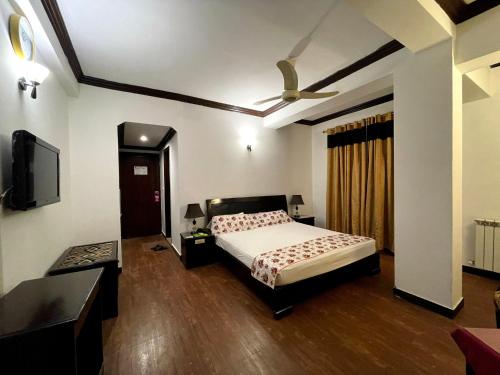 a bedroom with a bed and a ceiling fan at Grace Crown Hotel in Rawalpindi