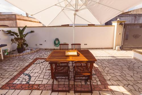 eine Terrasse mit einem Tisch, Stühlen und einem Sonnenschirm in der Unterkunft B&B Casa di Gio' in Tiggiano