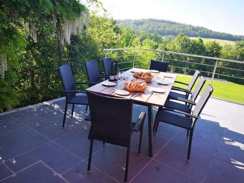 Una mesa y sillas de madera en un patio. en Villa Bon Temps Durbuy, en Durbuy