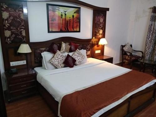 una camera da letto con un grande letto con cuscini sopra di Hotel New Empire a Nuova Delhi