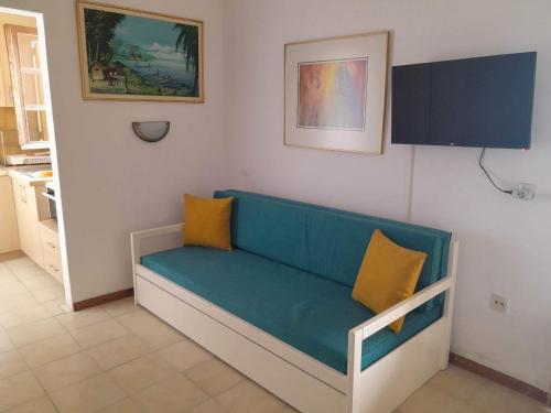 a blue couch with two yellow pillows in a room at Sunset studio in Pefkohori