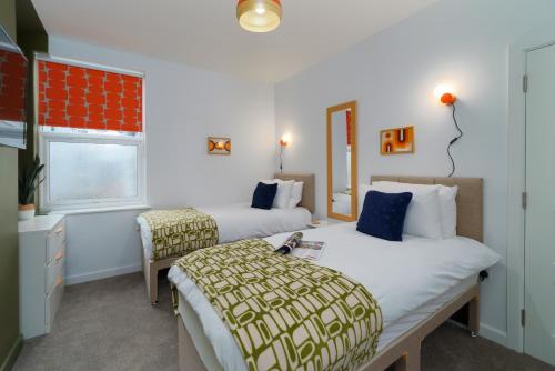 a hotel room with two beds and a window at Apartment Two - private car park, comfortable and well equipped - by Ocean City Retreats in Plymouth