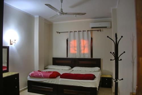 a bedroom with a bed with red pillows on it at Apartment im Al-Manar House Safaga in Hurghada