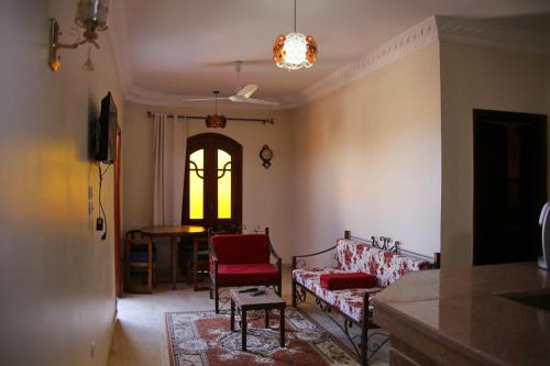 Apartment im Al-Manar House Safaga في الغردقة: غرفة معيشة مع كراسي حمراء وطاولة