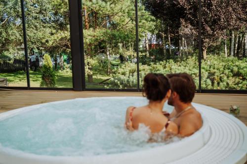 a man and woman sitting in a bath tub at Artis Loft Hotel in Radziejowice