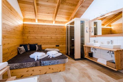 LiebenfelsにあるHochleben-Chalets am Erlebnisbauernhof Steinerhofのベッド1台、洗面台付きのバスルームが備わる客室です。