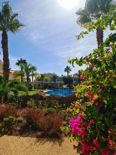 a garden with flowers and a swimming pool at Homefield Gardens by HnM in Conceição