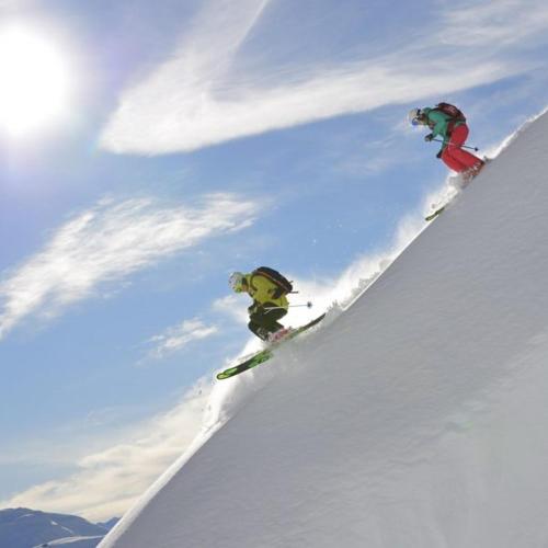two people are skiing down a snow covered slope at Chalet Marmotta CULM - Luxus Chalet Ski-In Ski-Out in Sankt Anton am Arlberg