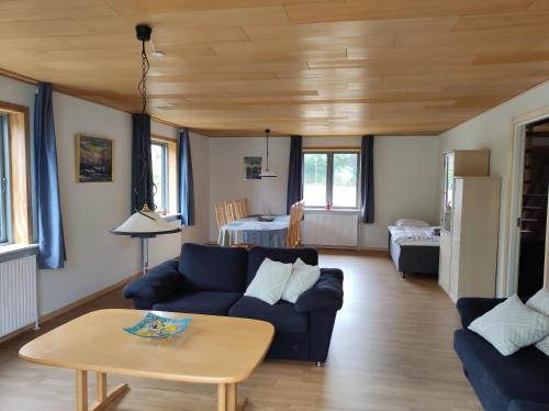 ein Wohnzimmer mit einem blauen Sofa und einem Tisch in der Unterkunft Hjortdal B&B in Fjerritslev
