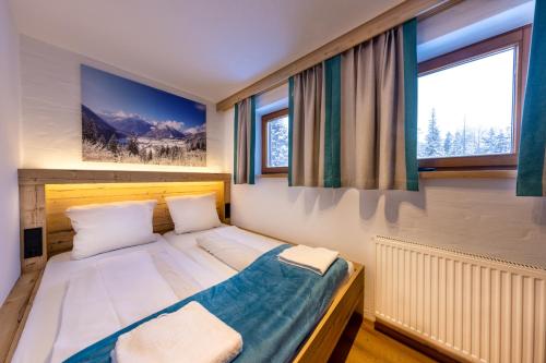 クリムルにあるHaus Wildkarblickの大きな窓付きの客室のベッド1台分です。