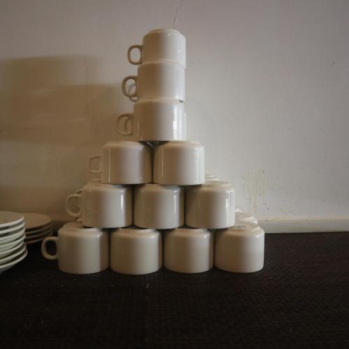 a stack of white cups sitting on a table at Sia Signature Calangute in Calangute