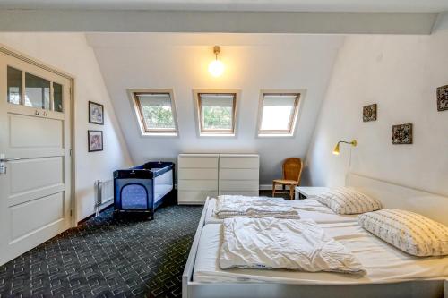 1 dormitorio con 2 camas, escritorio y ventanas en Vakantiehuis Nordseezauber - Callantsoog, en Callantsoog