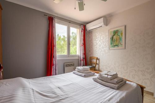 sypialnia z łóżkiem i ręcznikami w obiekcie Villa Cosy w mieście Moussan