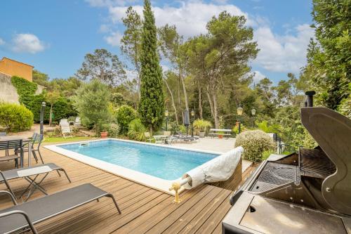 - une piscine sur une terrasse en bois avec un grill dans l'établissement Villa Cosy, à Moussan
