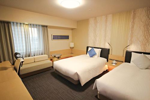 Habitación de hotel con 2 camas y sofá en Richmond Hotel Premier Musashikosugi, en Kawasaki