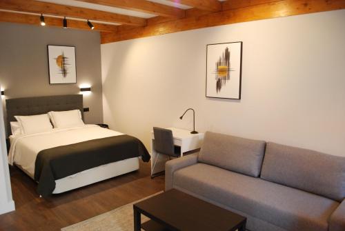 1 dormitorio con 1 cama y 1 sofá en ALTAR SUITES Caño Badillo en León