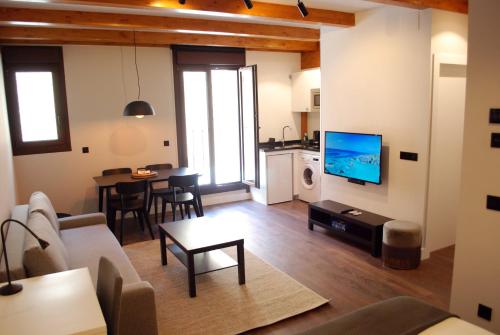 a living room with a couch and a tv at Altar Suites Caño Badillo by gaiarooms in León