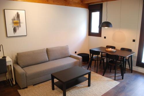 a living room with a couch and a table at Altar Suites Caño Badillo by gaiarooms in León