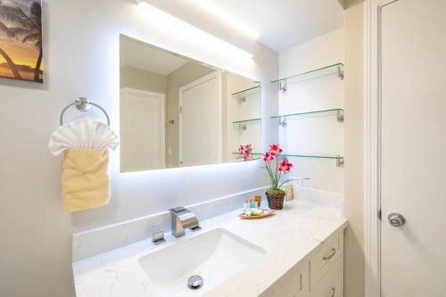 a bathroom with a sink and a mirror at Fabulous Ocean & Diamond Head View with Free Parking! in Honolulu