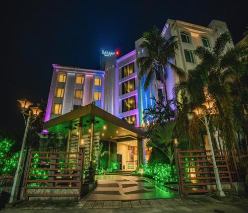 un hotel con luces moradas y verdes por la noche en Barsana Hotel & Resort Siliguri, en Siliguri